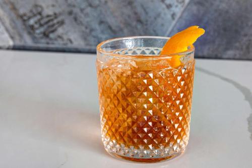 a glass filled with orange liquid sitting on a table at Home2 Suites Galveston, Tx in Galveston