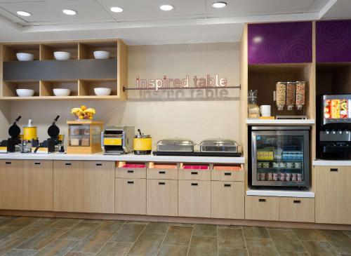 a restaurant kitchen with a counter with a refrigerator at Home2 Suites by Hilton Indianapolis - Keystone Crossing in Indianapolis