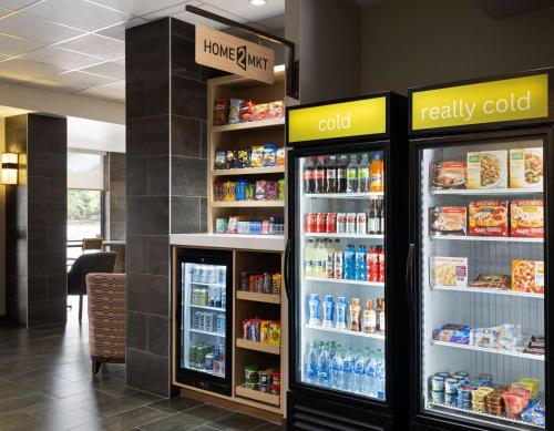 a store with two refrigerators with food and drinks at Home2 Suites by Hilton Indianapolis - Keystone Crossing in Indianapolis