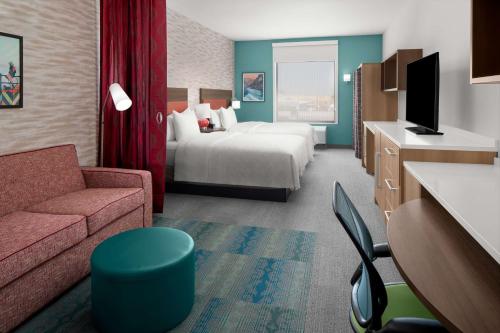 a hotel room with a bed and a couch at Home2 Suites By Hilton Hobbs in Hobbs