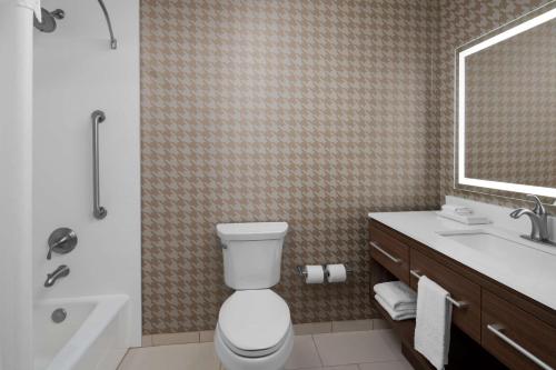 a bathroom with a toilet and a sink and a tub at Home2 Suites By Hilton Hobbs in Hobbs