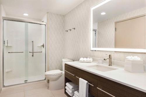 e bagno con servizi igienici, lavandino e doccia. di Home2 Suites By Hilton Leesburg, Va a Leesburg