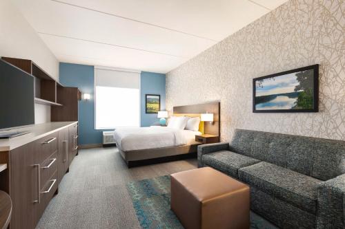 una camera d'albergo con letto e divano di Home2 Suites By Hilton Leesburg, Va a Leesburg