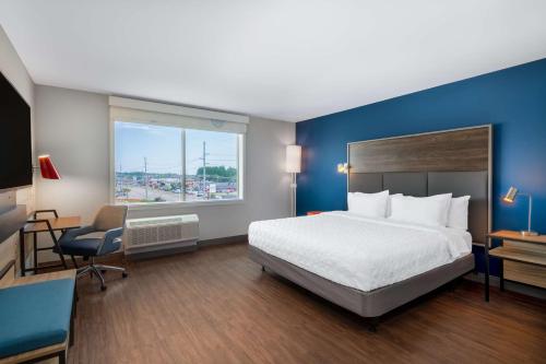 a hotel room with a bed and a desk and a window at Tru By Hilton Fayetteville Fort Bragg in Fayetteville