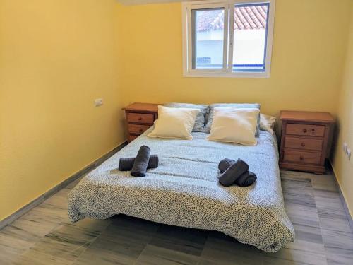 ein Schlafzimmer mit einem Bett mit zwei Paar Schuhen darauf in der Unterkunft Adosada en El Puerto Santa María in El Puerto de Santa María