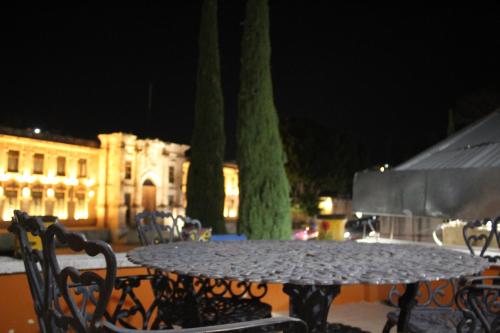 a table and chairs in front of a building at night at El Hogar de Carmelita in Guanajuato
