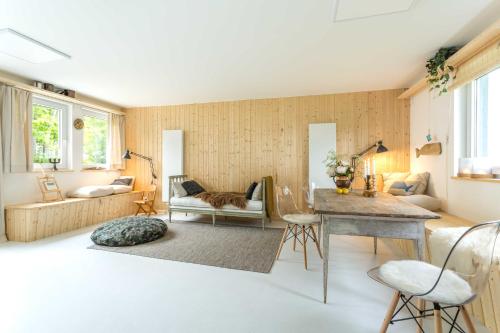 a living room with a table and a cat sitting on a couch at Herthaquelle Lazy "Maileen" in Garz-Rügen