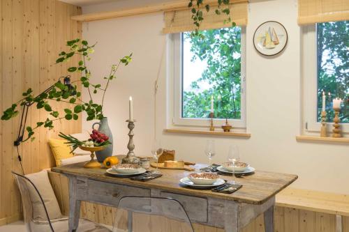 a dining room table with chairs and a clock on the wall at Herthaquelle Lazy "Maileen" in Garz-Rügen