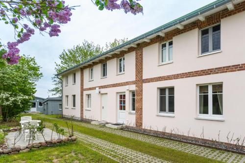 a large white house with a yard at Herthaquelle Lazy "Maileen" in Garz-Rügen