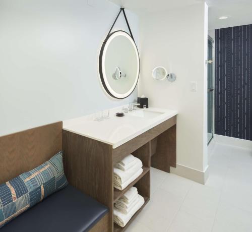 a bathroom with a sink and a mirror at The Chifley Houston, Tapestry Collection by Hilton in Houston