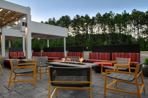 a patio with tables and chairs and a fire pit at Home2 Suites By Hilton Fayetteville North in Fayetteville