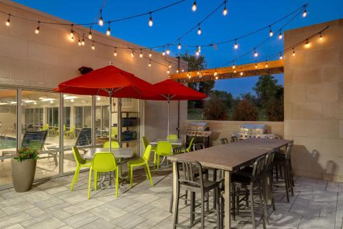 a patio with a table and chairs and lights at Home2 Suites By Hilton Grand Rapids Airport in Kentwood