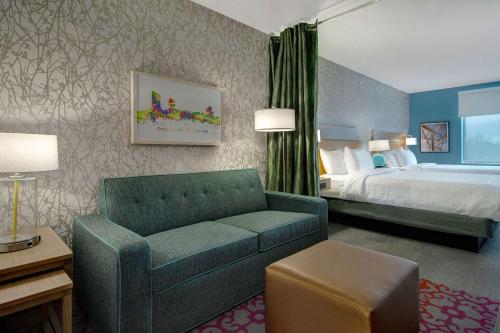 ein Hotelzimmer mit einem Sofa und einem Bett in der Unterkunft Home2 Suites By Hilton Grand Rapids Airport in Kentwood