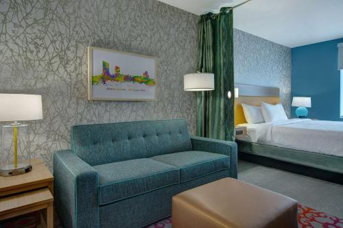 a hotel room with a couch and a bed at Home2 Suites By Hilton Grand Rapids Airport in Kentwood