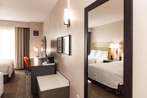a hotel room with two beds and a mirror at Hampton Inn & Suites By Hilton- Newark Airport Elizabeth in Newark