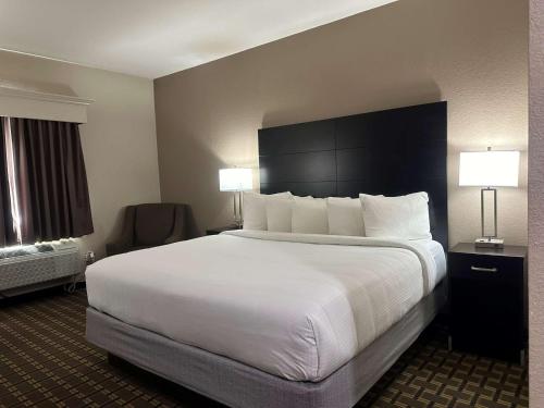 a large bed in a hotel room with two lamps at Best Western Halito Inn in Calera
