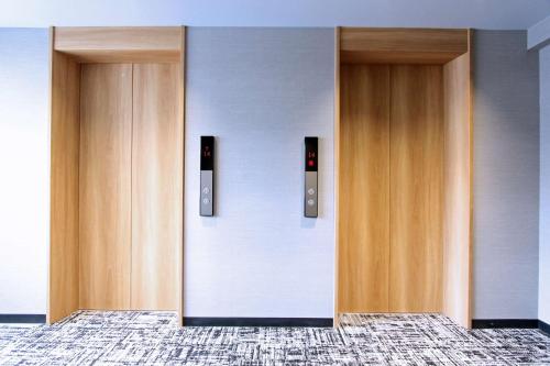 two wooden elevator doors in a building at Best Western Plus Nagoya Sakae in Nagoya