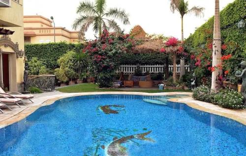 una gran piscina azul en un patio en Luxury Villa in Rehab City en El Cairo