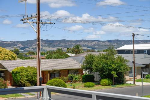 a house on a street with mountains in the background at Casa Bianca - Aldinga Beach - C21 SouthCoast Holidays in Aldinga Beach