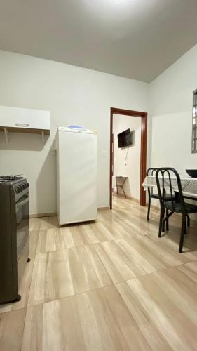 a kitchen with a white refrigerator and a table at Casa de temporada in Olímpia