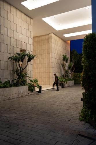 a person walking in a building with a person walking at The Capital Hotel Surabaya in Surabaya