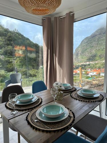 a dining room table with a view of a mountain at The Green Valley House in São Vicente