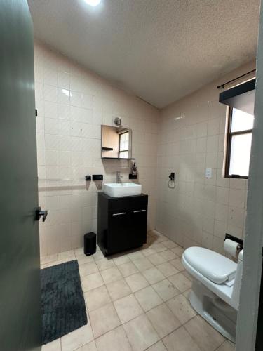 a bathroom with a toilet and a sink at Santa Madre B&B in San Luis Potosí