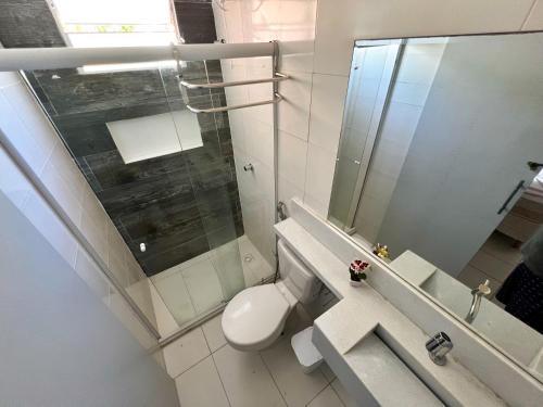 uma casa de banho com um WC e uma cabina de duche em vidro. em Chalés Coco Verde - Praia de Itacimirim em Itacimirim