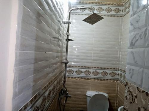 y baño con ducha y aseo. en Egypt Pyramids Hotel en El Cairo