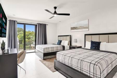 劳德代尔堡New 4BR w Pool Walk to Las Olas 5mins to Beach的带两张床和吊扇的卧室