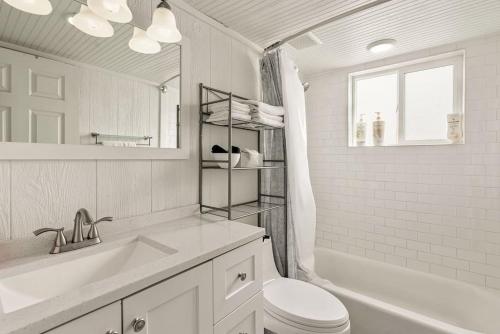 a white bathroom with a toilet and a tub and a sink at Central Location Walking Distance to Restaurants in Provo
