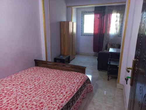 a bedroom with a bed with a red comforter at Pyramids Hotel in Cairo