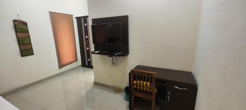 a room with a desk and a television on a wall at Stayz Inn Hotels - T nagar Chennai Near Pondy Bazzar in Chennai