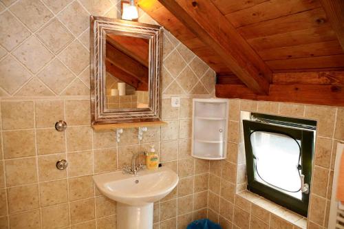 łazienka z umywalką i lustrem w obiekcie Holiday home in Starigrad-Paklenica 41708 w mieście Starigrad-Paklenica