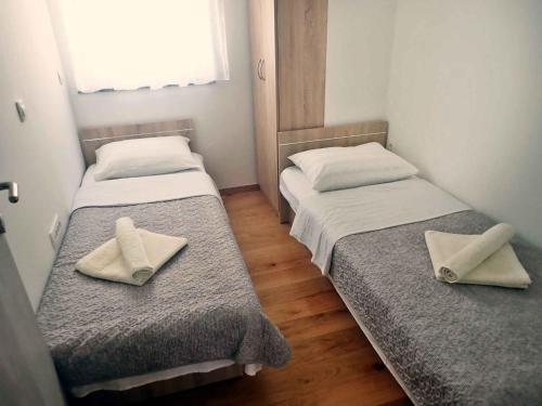 - 2 lits dans une petite chambre avec des serviettes dans l'établissement Holiday home in Jasenice 40484, à Jasenice
