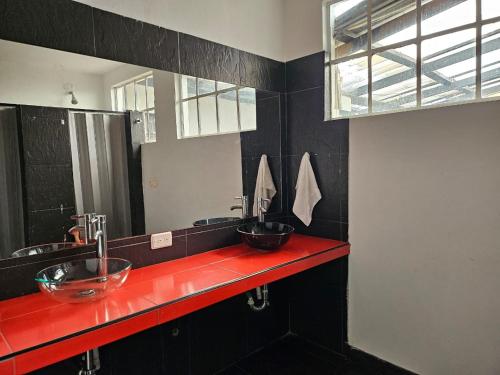 baño con 2 lavabos y encimera roja en Casa Samor La Candelaria en Bogotá