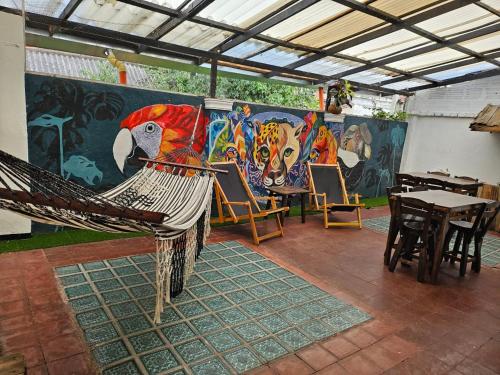 a room with tables and chairs and a mural at Casa Samor La Candelaria in Bogotá