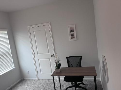 um quarto com uma mesa, uma cadeira e uma porta em Home away from Home em Manvel