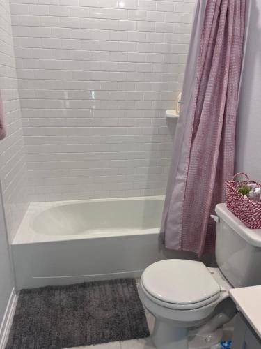 uma casa de banho com uma banheira branca e um WC. em Home away from Home em Manvel