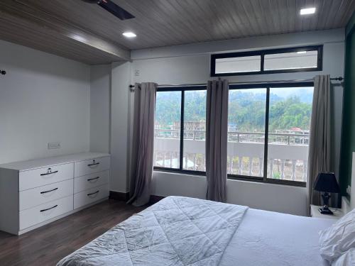 a bedroom with a bed and a large window at BKR Homestay 1BH in Itānagar