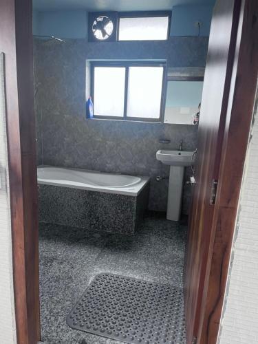 a bathroom with a bath tub and a sink at BKR Homestay 1BH in Itānagar