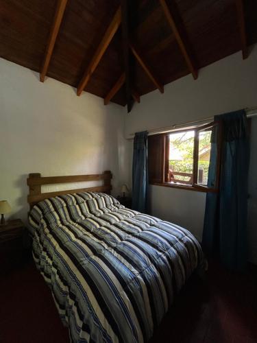 1 cama en un dormitorio con ventana en FloChris Villa Gesell Zona Norte SOLO FAMILIAS en Villa Gesell