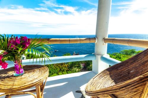 a vase of flowers sitting on a chair on a balcony at Villas Mykonos in Zipolite