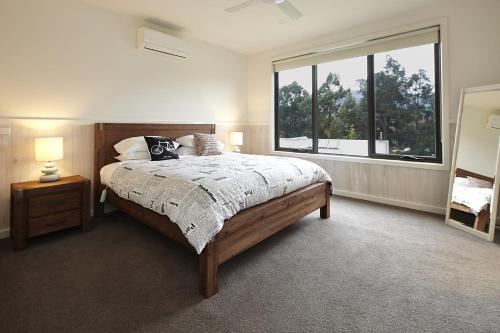 ein Schlafzimmer mit einem Bett und einem großen Fenster in der Unterkunft Blue Haven In Bright Victoria in Bright