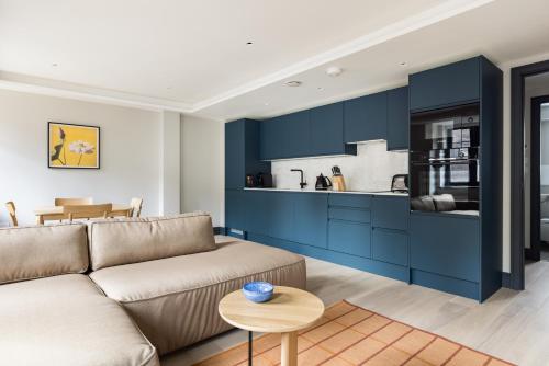 a living room with a couch and a kitchen at Covent Garden Apartments in London