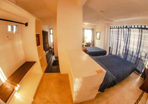 a small room with a bed and a desk at Villas Mykonos in Zipolite