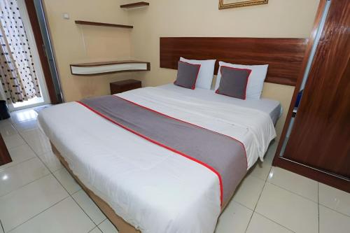- une chambre avec un grand lit blanc et 2 oreillers dans l'établissement Asia Room at Green Lake View Apartment, à Jakarta