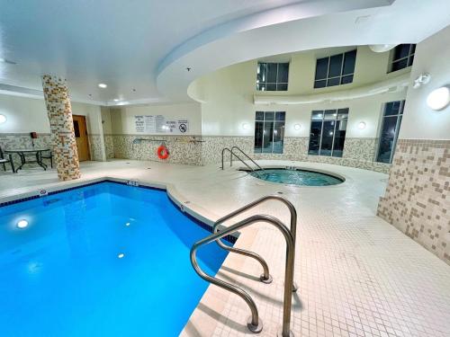 una gran piscina con bañera de hidromasaje en un edificio en Chateau Inn & Suites Bonnyville, en Bonnyville