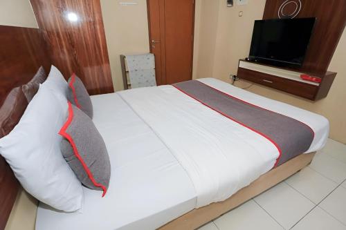 - une chambre avec un grand lit et une télévision murale dans l'établissement Asia Room at Green Lake View Apartment, à Jakarta