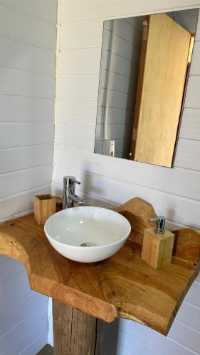 a sink on a wooden counter with a mirror at La Cabaña Punta Negra in Punta Colorada